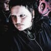alternative styled person with piercings, black mullet haircut and cool stainless steel jewellery. image is from a brand photoshoot and has graffiti in the background.
