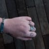 an image of a stainless steel bracelet on the wrist of someone with a wrist tattoo. the bracelet contains segments made from pieces of vintage stainless steel cutlery.