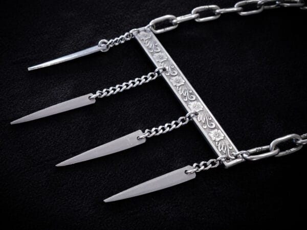 a stainless steel necklace made from the handle and fork tines of a vintage fork.