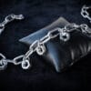 a necklace made from chunky stainless steel chain and hex nuts as charms along it.