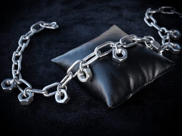 a necklace made from chunky stainless steel chain and hex nuts as charms along it.