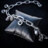 a necklace made from chunky stainless steel chain and hex nuts as charms along it.