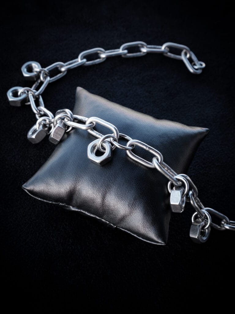a necklace made from chunky stainless steel chain and hex nuts as charms along it.