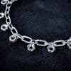 a necklace made from chunky stainless steel chain and hex nuts as charms along it.