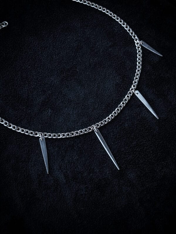 a stainless steel curb chain necklace with fork tines as charms