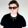 a woman with sunglasses and a black shirt on wearing a stainless steel curb chain necklace with fork tines as charms for a product photoshoot